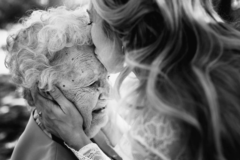black and white moment of bride kissing her grandma