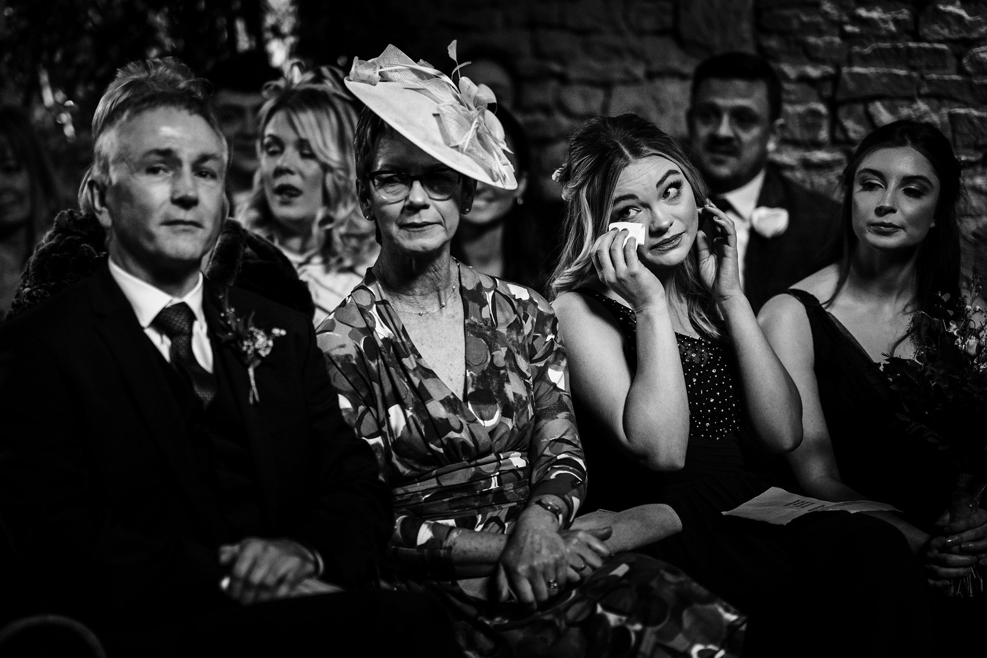 bridesmaid in wedding wipes her eyes during wedding ceremony